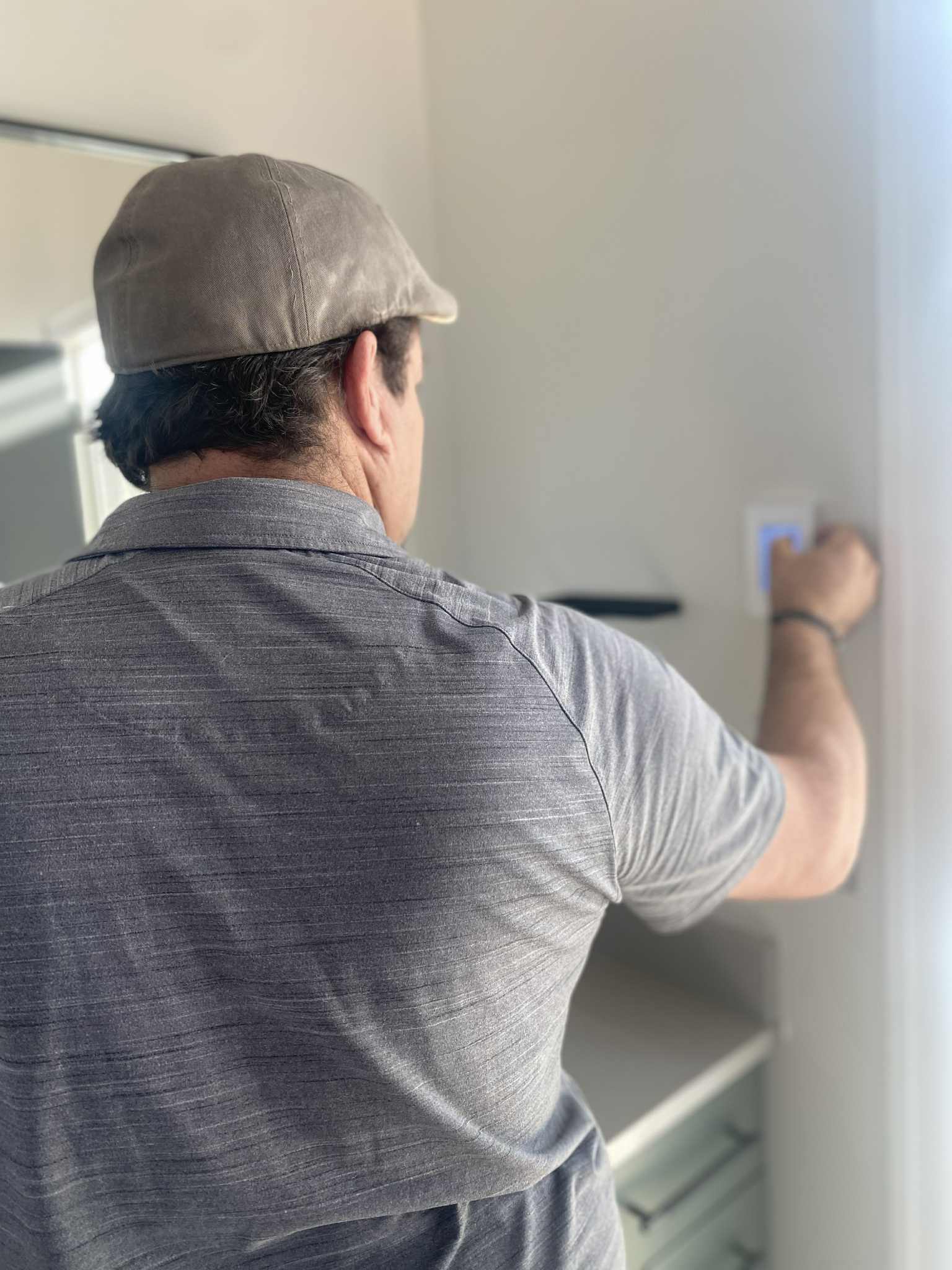 Tony checking a wall control during a home maintenance visit
